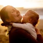 Woman Carrying Baby in White Long Sleeve Shirt