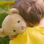 boy hugging teddy bear