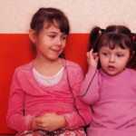 child sharing earphones