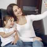 Smiling mother and daughter taking selfie