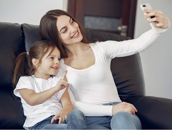 Smiling mother and daughter taking selfie