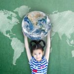 Happy Asian girl child student raising globe