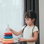 Little Girl Playing with Colorful Toy