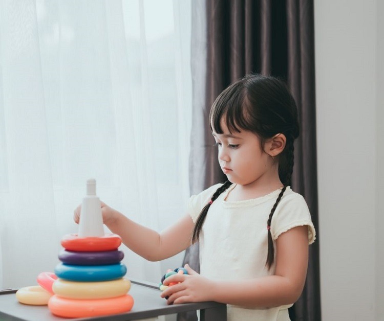 Little Girl Playing with Colorful Toy